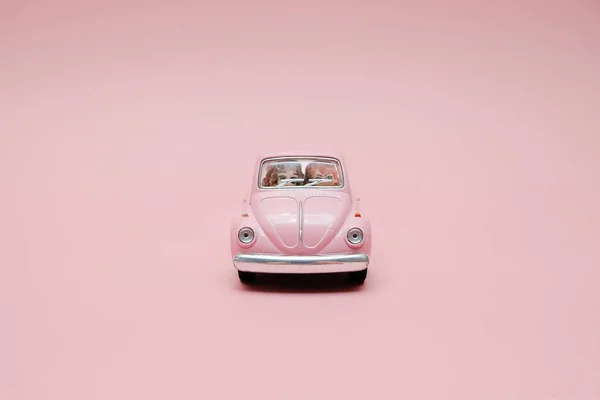 Pink retro toy car delivering bouquet of flowers box on pink background. February 14 card for Valentine's day. Flower delivery. 8 March, International Happy Women's Day. — Stock Photo, Image