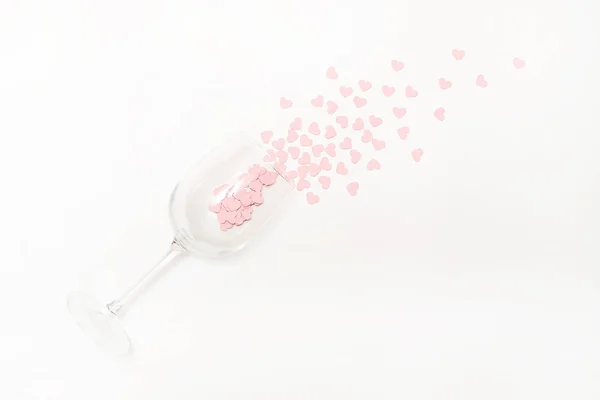 Weingläser mit rosa Herzen Konfetti auf weißem Hintergrund. flache Lage, Draufsicht. Feiertags- und Feiertagskonzept. 14. Februar Karte für den Valentinstag — Stockfoto