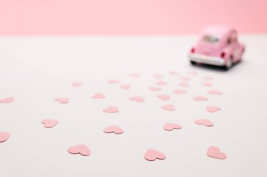Pembe retro oyuncak araba pembe kalpler kutusunda teslim. 14 Şubat Sevgililer günü kartı. Çiçek teslim. 8 Mart, mutlu Dünya Kadınlar günü.