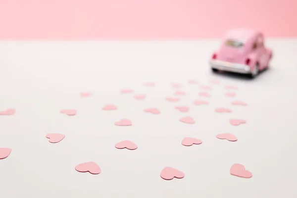 Carro de brinquedo retro rosa entregando caixa de corações no fundo rosa. 14 de fevereiro cartão para o dia dos namorados. Entrega de flores. 8 de março, Dia Internacional da Mulher Feliz . — Fotografia de Stock