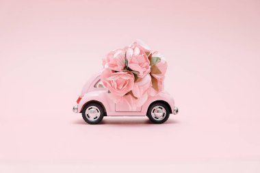 Buket çiçek kutusu pembe bir arka plan üzerinde teslim pembe retro oyuncak araba. 14 Şubat Sevgililer günü kartı. Çiçek teslim. 8 Mart, mutlu Dünya Kadınlar günü.