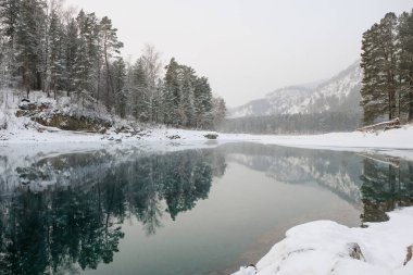 Göl ile kar yansıtan buz dağları kaplı. Altay Dağları'nda mavi göl