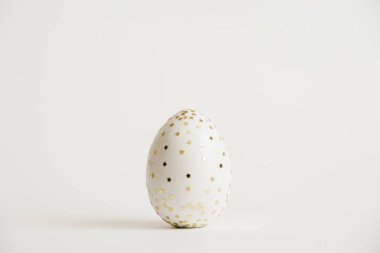 Beyaz arka plan üzerinde izole parlak yıldız ile beyaz Paskalya yumurtası. En az Paskalya kavramı. Üstten Görünüm, flatlay.  