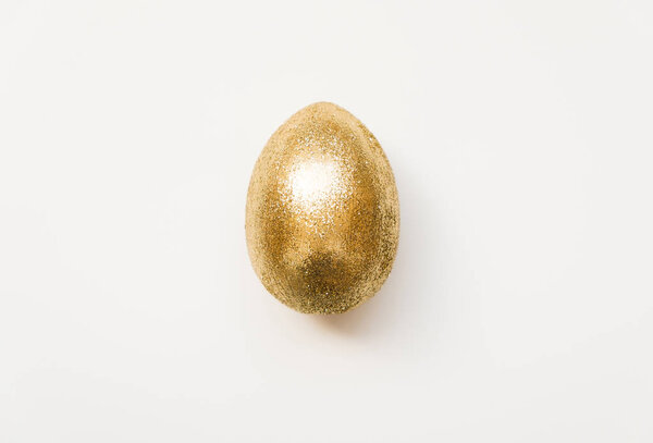 Easter golden glitter egg  isolated on white background. Minimal easter concept. Happy Easter card. Top view, flatlay.  