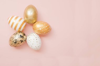 Paskalya altın yumurta pastel pembe arka plan üzerine dekore edilmiştir. En az Paskalya kavramı. Metin kopya alanı ile mutlu Paskalya kartı. T