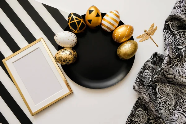 Fondo elegante con decoración. Composición con huevos dorados de Pascua en plato negro. Moderno concepto de pascua plana lay — Foto de Stock