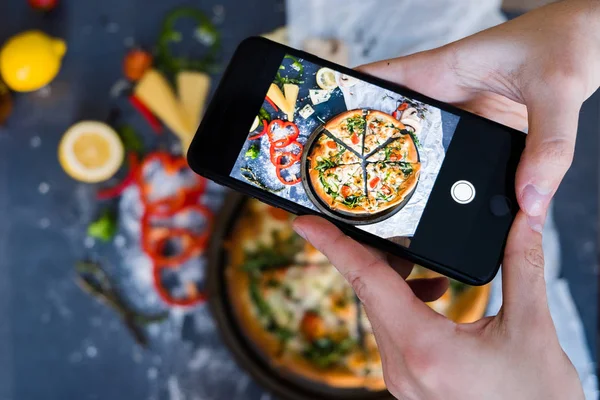 Man taking photo of pizza with smartphone Closeup view of process