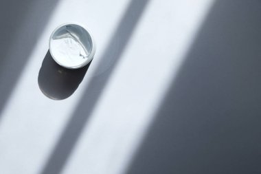Düz bir kavanoz mavi kil temizleyici maskesi ile yatıyordu. Yüz kozmetik ürünleri ile güzellik arka plan