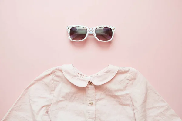 Nyári gyermek ruházat, rózsaszín háttérrel. Kislány divat Nézd meg az ing és szemüveg — Stock Fotó