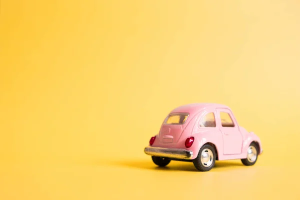 Omsk, Russia - May 26, 2019: Pink retro toy car on yellow backgr — Stock Photo, Image