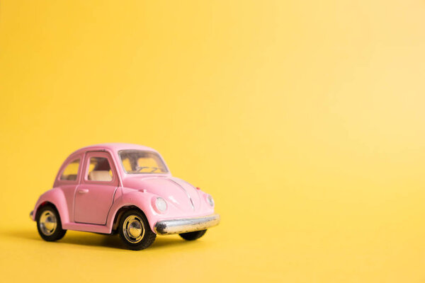 Омск, Россия - 26 мая 2019 года: Pink retro toy car on yellow backgr
