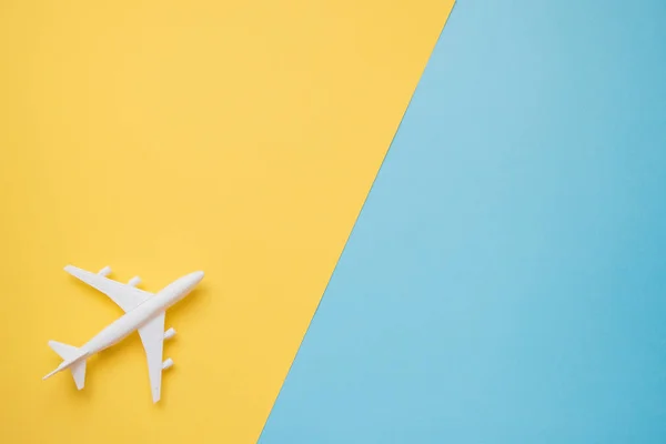 Flat lay design of travel concept with plane on blue and yellow
