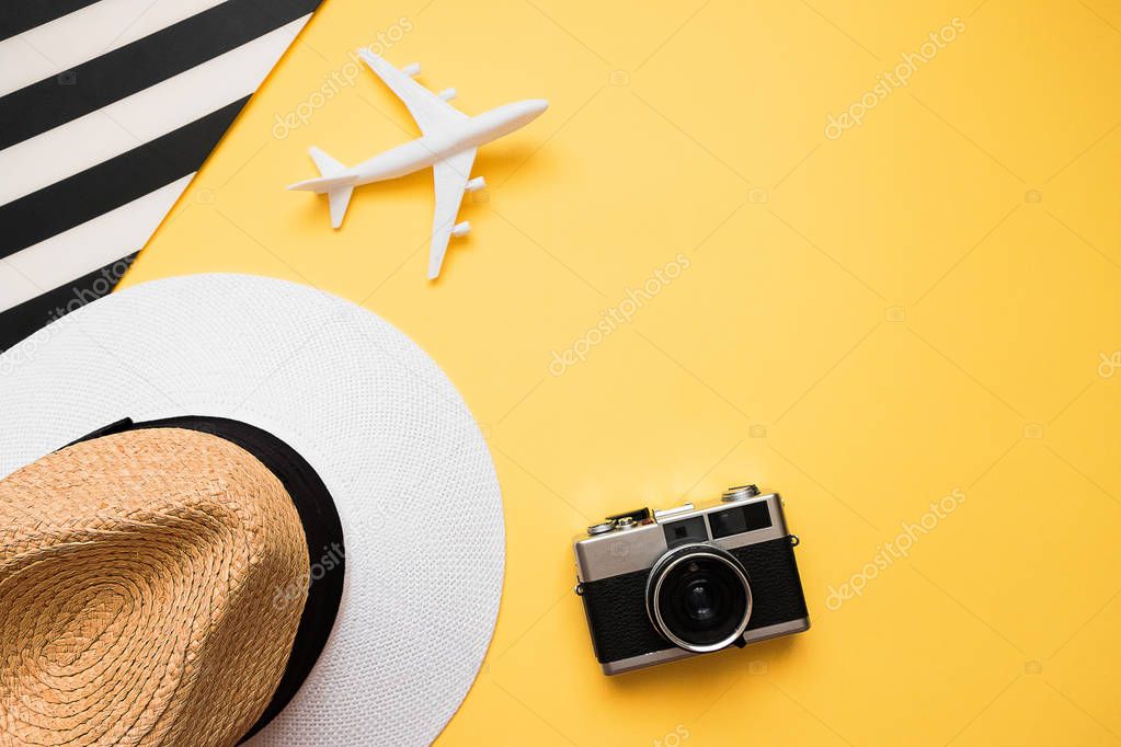 Summer background with hat, plane and camera. Flat lay traveler 