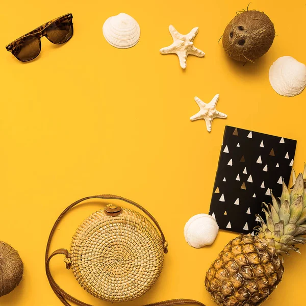 Summer traveler accessories flat lay. Straw hat, camera, bag, sunglasses, coconut, pineapple, plane, notebook and phone on yellow — Stock Photo, Image