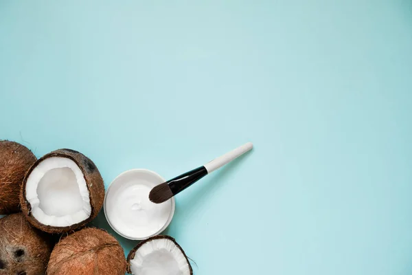 Frisches Kokosöl in Glas und Holzlöffel auf farbigem Tischhintergrund. — Stockfoto