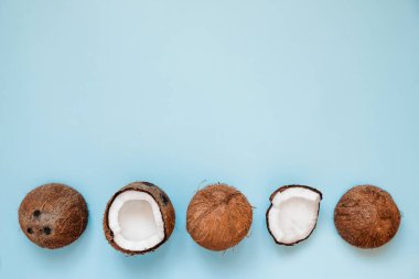 Olgun ve mavi arka plan üzerinde hindistan cevizi açıldı Satır. Üst Görünüm. Kopya Alanı. Pop art tasarımı, yaratıcı yaz konsepti. Afiş. Minimal düz yatıyordu tarzıhindistan cevizi yarısı