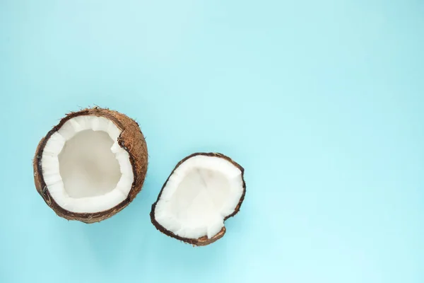 Płaski lay z otwartym kokosowym na niebieskim tle. Minimalny styl — Zdjęcie stockowe