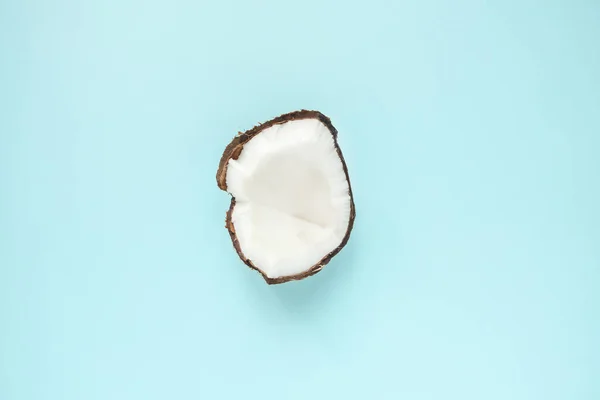 Kreatywny układ wykonany z pół dojrzałego kokosa na niebieskim tle. Płaski lay w minimalistycznym stylu — Zdjęcie stockowe