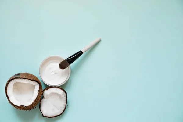 Świeży olej kokosowy w szklanych i drewnianych łyżce na tle tabeli kolorów. — Zdjęcie stockowe