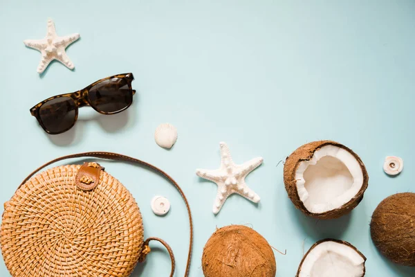 Flat lay with ripe coconuts on blue background. Creative summer layout with sunglasses, straw hat, bamboo bag, starfish and sea shells. — Stock Photo, Image