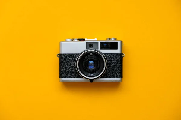 Retro Film Camera on yellow background. Photo shooting. Pop Art. Hipster Trendy Vintage Accessories. Minimal flat lay