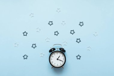 Çalar saat mavi arka planda izole. Uyanma zamanı. Okula geri düz yatıyordu