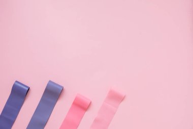 Pembe arka plan üzerinde Fitness elastik bant. Renkli genişletici diş etleri.