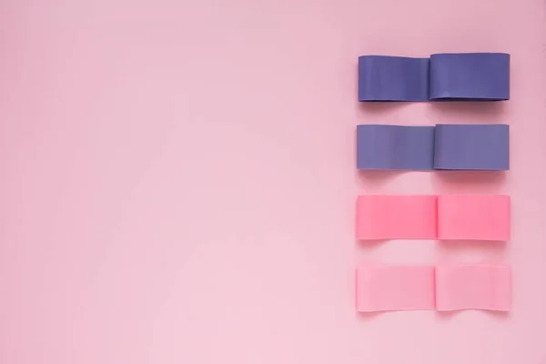 Encías de fitness coloridas sobre fondo rosa. Ampliadores elásticos — Foto de Stock