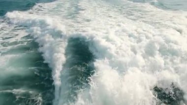 Denizde büyük bir yolcu gemisinin arkasındaki yavaş çekim görüntüsü. Okyanusta gemi gezisi. Bir geminin arkasından deniz yüzeyinin üzerinden görüntüyü izle.