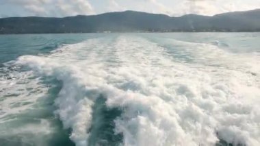 Denizde büyük bir yolcu gemisinin arkasındaki yavaş çekim görüntüsü. Okyanusta gemi gezisi. Bir geminin arkasından deniz yüzeyinin üzerinden görüntüyü izle.