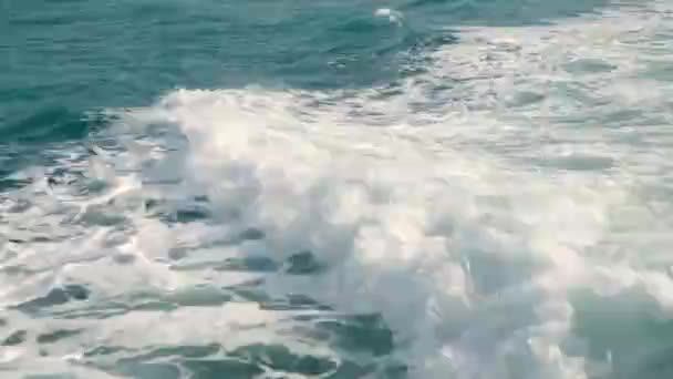 En slow motion vy över vakan bakom ett stort kryssningsfartyg till sjöss. Fartyget seglar på oceanen. Utsikt från baksidan av ett fartyg över vattenytan i havet — Stockvideo