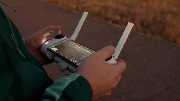Homme opérant un drone avec télécommande. Homme contrôlant drone pendant le vol. Mains tenant une télécommande de drone et enregistrant une vidéo. — Video
