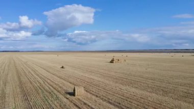 Bulutlu bir sonbahar gününde sonsuz tarla manzarası. Drone kırsal kesimlerdeki buğday tarlaları üzerinde uçuyor. Açık Mavi Gökyüzü.