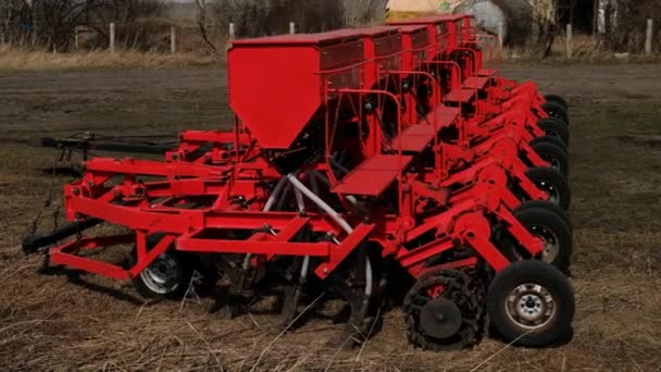 Modern menabur mesin benih. Penanaman traktor petani. Merah menggabungkan bajak. Menabur tanaman di lahan pertanian di musim semi — Stok Video