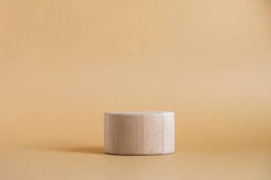 Bej arka planda ahşap yuvarlak silindir şekli. Minimum kutu ve geometrik podyum. Geometrik şekilli sahne. Eko kozmetik ürün sunumu için boş bir vitrin. Moda dergisi.