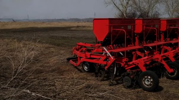 Moderne zaaimachine. Boer trekker zaaien. Rood combineer ploeg. Zaaien van gewassen op landbouwvelden in het voorjaar — Stockvideo