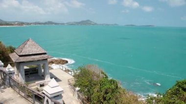 Samui 'ye Lad Koh bakış açısı. Güçlü dalgalar ve deniz köpüğüyle kayalık bir sahilde kırılma sesleri. Mavi gök mavisi deniz suyu, deniz kıyısı, taş kıyısı