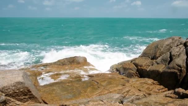 Onde potenti e spruzzi che si infrangono su una spiaggia rocciosa con schiuma di mare. Blu azzurro acqua di mare, riva del mare, costa di pietra. — Video Stock