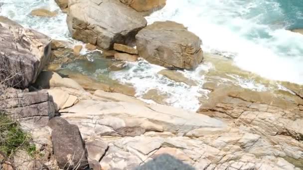 Powerful Waves and splashes breaking on a rocky beach with sea foam. Blue azure sea water, sea shore, stone coast. — Stock Video