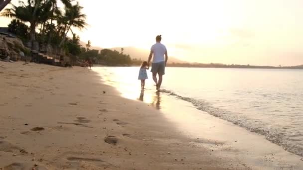 Famiglia felice sulla spiaggia di mare al resort. Padre e figli che giocano sulla spiaggia all'ora del tramonto. Vacanze estive tropicali — Video Stock