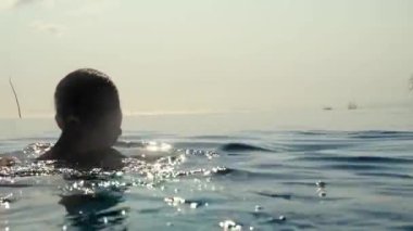 Sonsuz yüzme havuzunda dinlenen kadın manzaraya bakıyor.