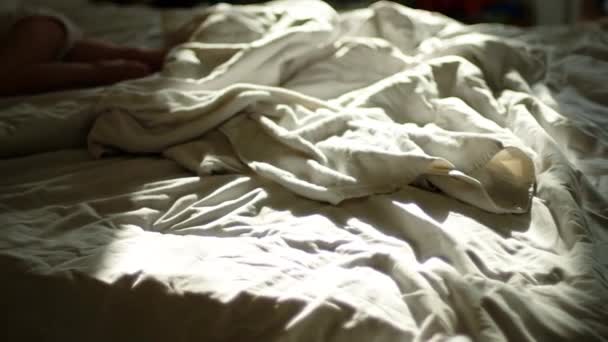 Leeg bed in moderne tropische hotelkamer bij zonsopgang. Zon schijnt door het raam met lensflare effecten. — Stockvideo