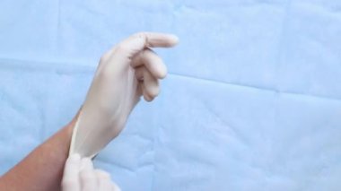 Beyaz tıbbi eldiven giyen doktorların yakın çekimleri. Eczacı, terapist ya da eldiven takan doktor. Tıbbi ve sağlık hizmetleri konsepti. Doktorun ellerine yakın çekim. Üst Manzara. Birinci kişi görünümü