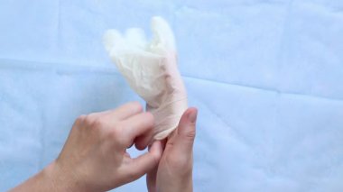 Beyaz tıbbi eldiven giyen doktorların yakın çekimleri. Eczacı, terapist ya da eldiven takan doktor. Tıbbi ve sağlık hizmetleri konsepti. Doktorun ellerine yakın çekim. Üst Manzara. Birinci kişi görünümü