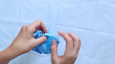 Mavi tıbbi eldiven giyen doktorların yakın çekimleri. Eczacı, terapist ya da eldiven takan doktor. Tıbbi ve sağlık hizmetleri konsepti. Doktorun ellerine yakın çekim. Üst Manzara. Birinci kişi görünümü