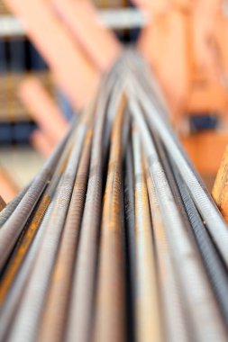 Metal depodaki takviye, seçici odaklanma. Pas lekeli demir çubuklar. Çelik takviyesine yakın çekim. İnşaat malzemeleri deposu. Onarım ve inşaat konsepti