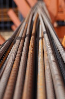 Metal depodaki takviye, seçici odaklanma. Pas lekeli demir çubuklar. Çelik takviyesine yakın çekim. İnşaat malzemeleri deposu. Onarım ve inşaat konsepti