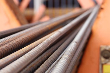 Metal depodaki takviye, seçici odaklanma. Pas lekeli demir çubuklar. Çelik takviyesine yakın çekim. İnşaat malzemeleri deposu. Onarım ve inşaat konsepti