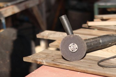 Açı öğütücüler, inşaat ve onarım için elektrikli aletler. Sert materyalleri kesip öğütmek için bir araç. Kablosu olan eski bir kıyma makinesi. Ülkedeki tamirat işleri. Metal diskle öğütücü