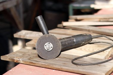 Açı öğütücüler, inşaat ve onarım için elektrikli aletler. Sert materyalleri kesip öğütmek için bir araç. Kablosu olan eski bir kıyma makinesi. Ülkedeki tamirat işleri. Metal diskle öğütücü